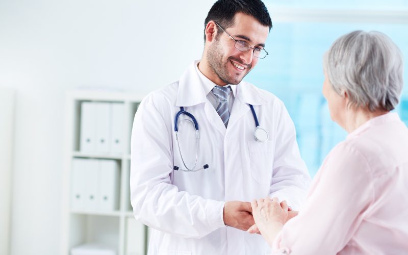 Confident doctor looking at his senior patient while speaking to her